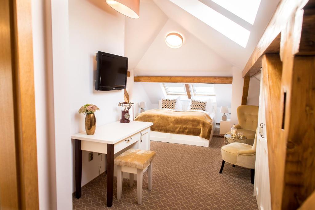 ein Schlafzimmer mit einem Bett und einem Schreibtisch in einem Zimmer in der Unterkunft Hotel Golfi in Poděbrady