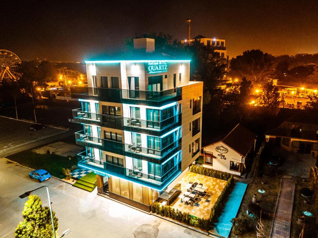 a building with a hotel sign on it at night at Quartz Boutique Hotel in Mamaia