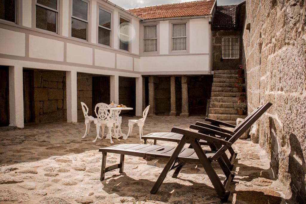 un patio con mesa y sillas frente a un edificio en Casa dos Muiños, en Pontevedra