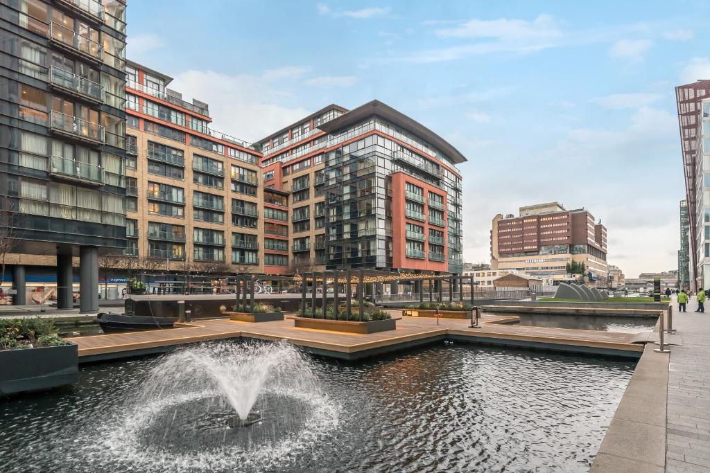 a fountain in the middle of a city with tall buildings at Merchant Square Paddington in London