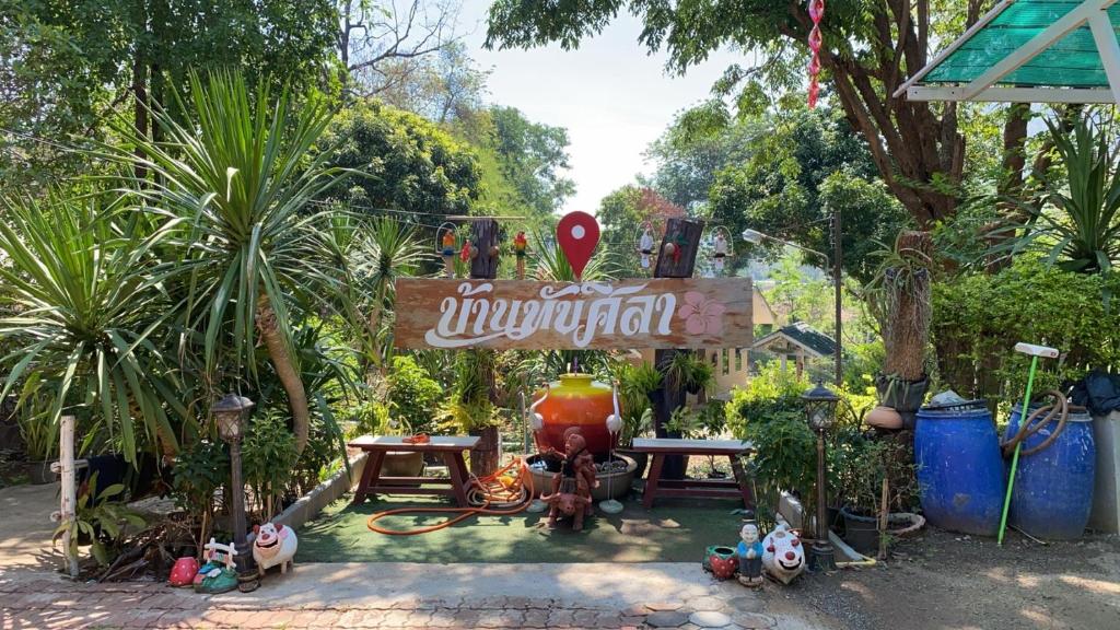 een tuin met een bord en wat planten en bomen bij ทับศิลารีสอร์ท Tubsila Resort in Chongsadao