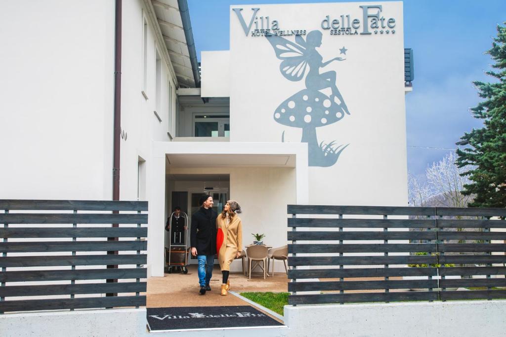un homme et une femme marchant devant un bâtiment dans l'établissement Hotel Villa delle Fate, BW Signature Collection, à Sestola