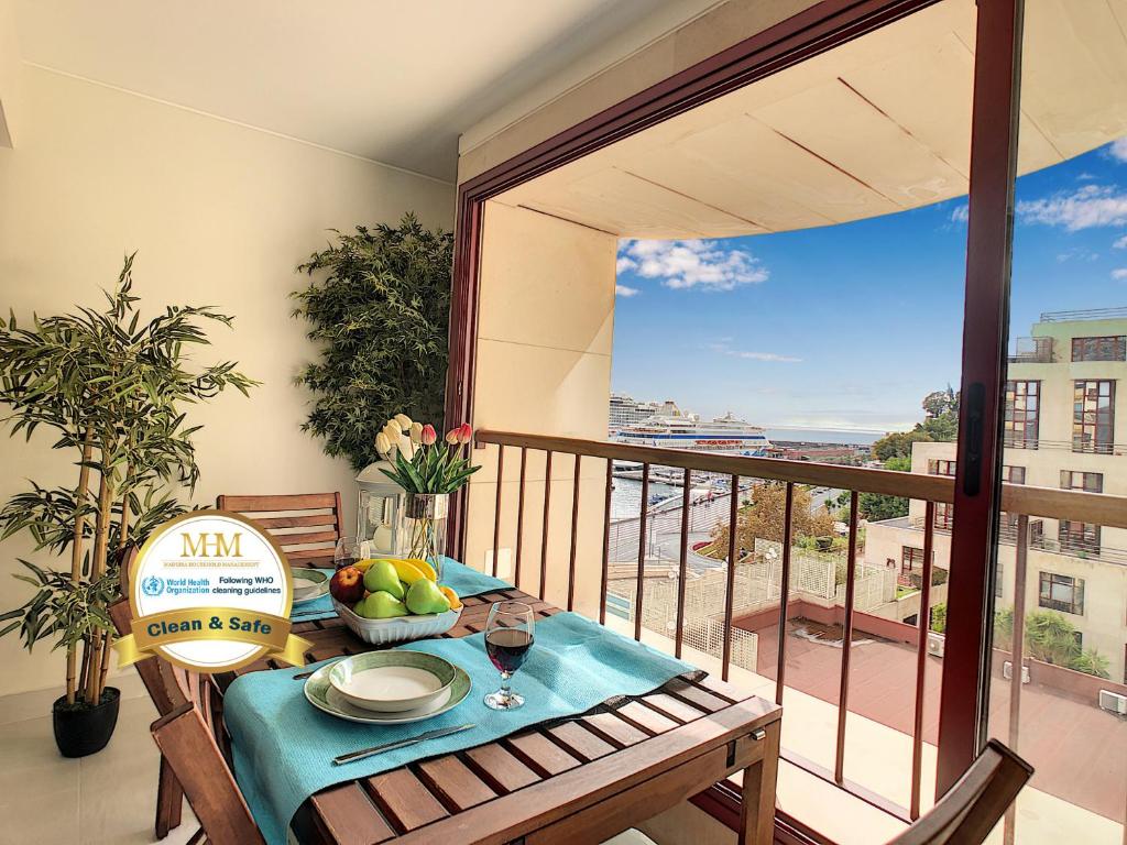 einen Balkon mit einem Tisch und einer Obstschale darauf in der Unterkunft Tropical Sun by LovelyStay in Funchal
