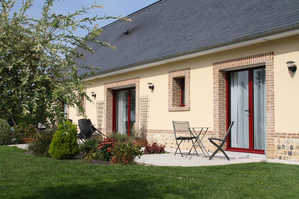 una casa con dos sillas en el patio delantero en Le Clos Marie en Sausseuzemare-en-Caux