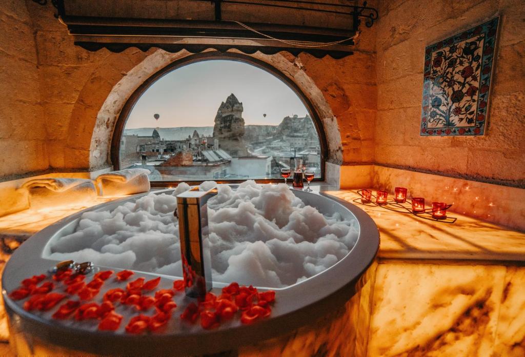 a bath tub filled with snow in a room with a window at Erenbey Cave Hotel in Göreme