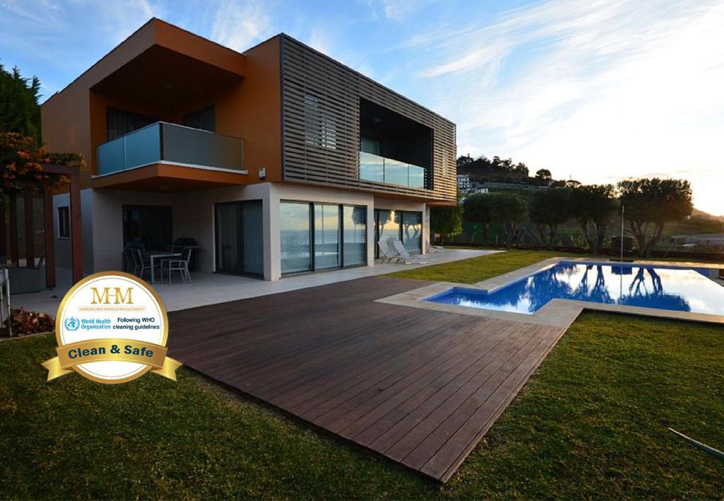 une maison avec un panneau en face d'une piscine dans l'établissement Villa Vitoria - by LovelyStay, à Funchal