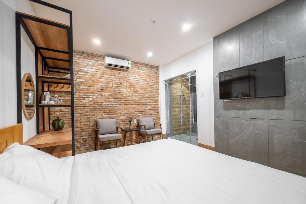 a bedroom with a large bed and a brick wall at Coast House Boutique Hotel in Nha Trang