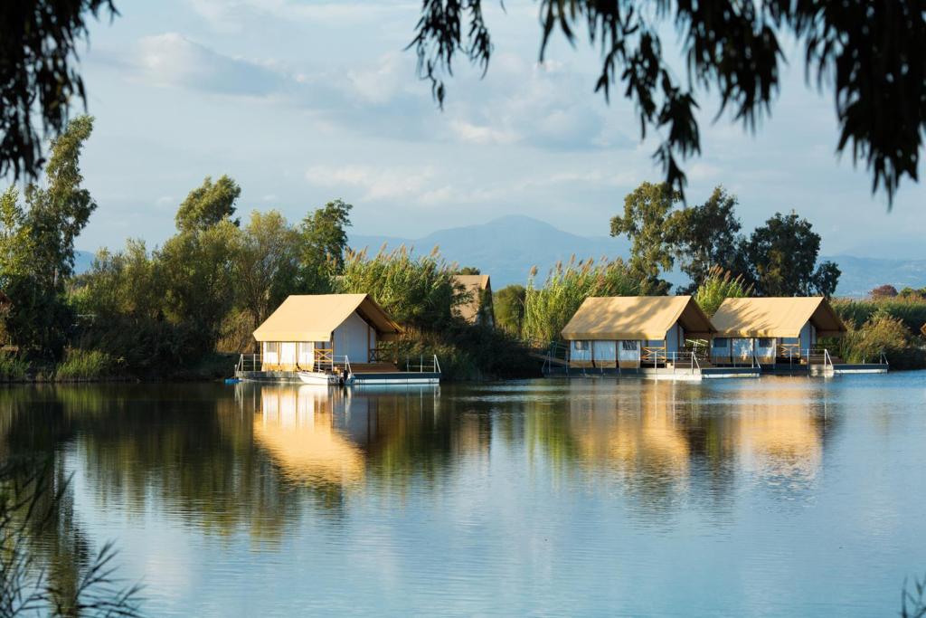 a group of cottages on a lake at Nabi Resort Glamping & SPA in Castel Volturno