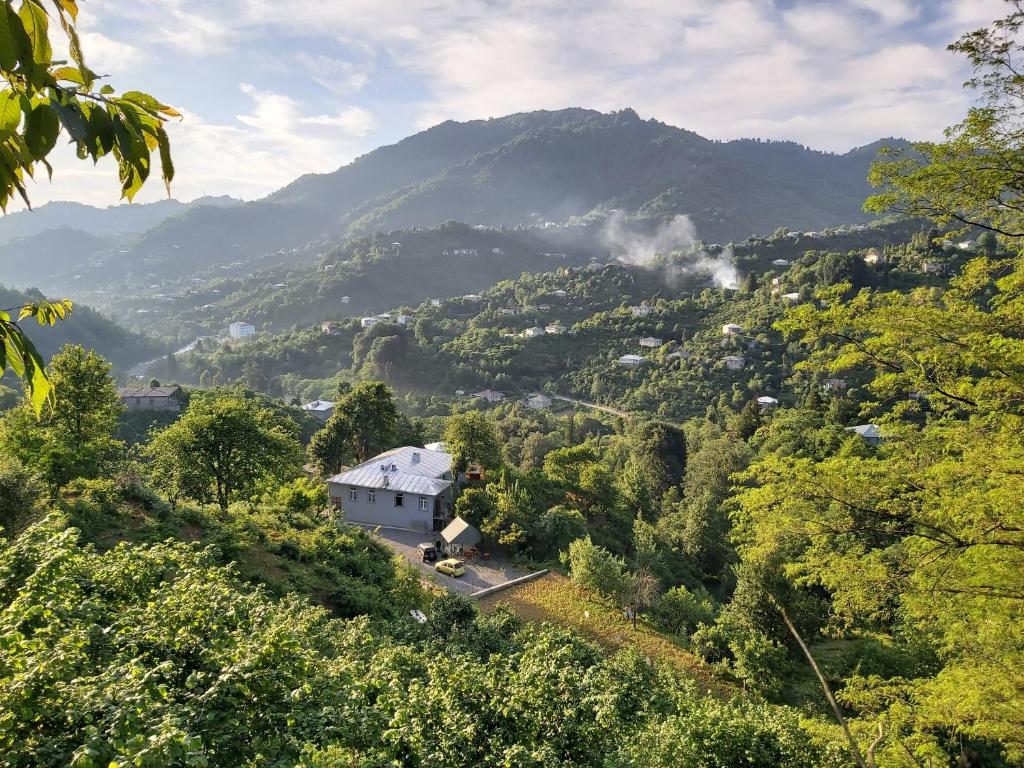 una casa en una colina con montañas en el fondo en Mtirala House en Khala