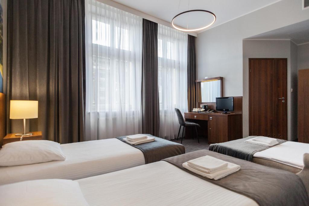 Łóżko lub łóżka w pokoju w obiekcie Hotel Downtown Kraków