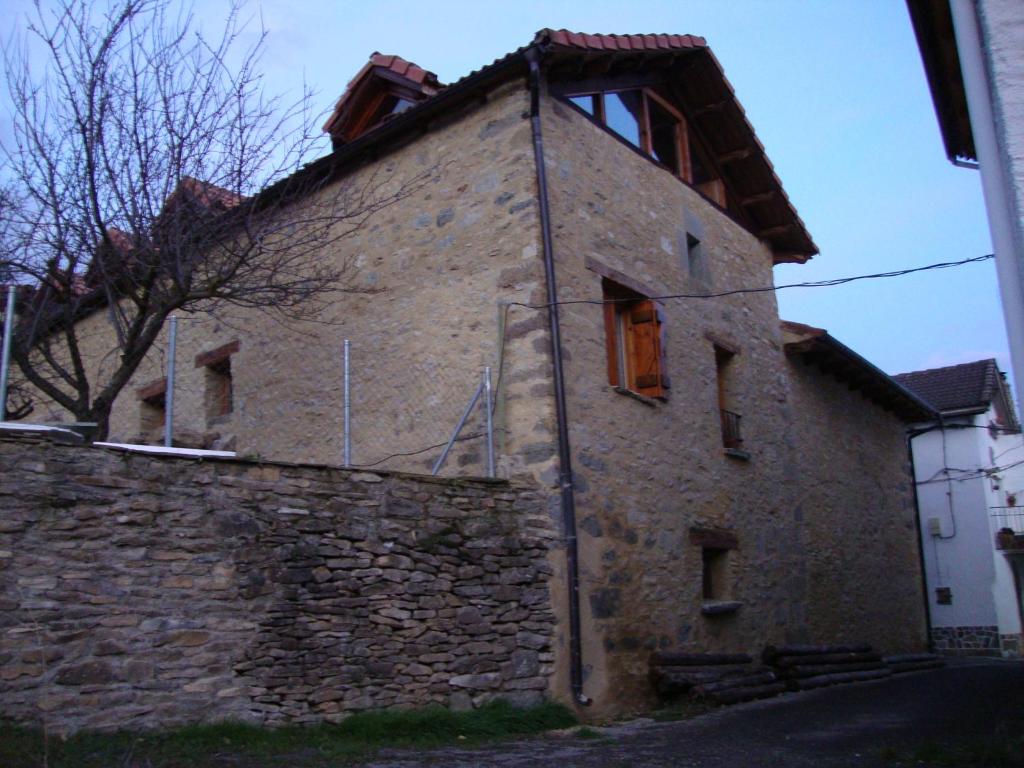 un edificio de piedra con una ventana en el lateral. en O´Porron, en Sabiñánigo