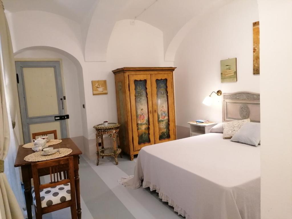 sypialnia z białym łóżkiem i drewnianą szafką w obiekcie La Casa del Cuore w Turynie