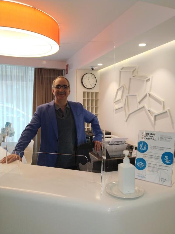 a man is standing in front of a counter at Hotel Parma in San Sebastián