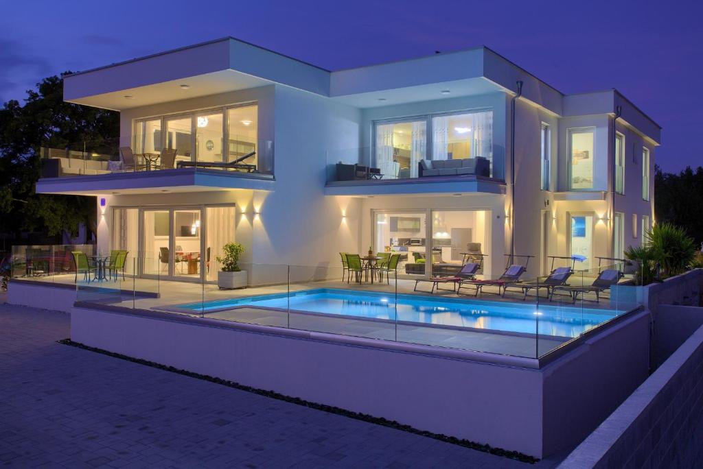 a large house with a swimming pool in front of it at Villa Helines***** in Linardići