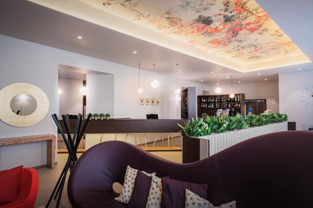 Hotel San Giovanni Roma في روما: غرفة معيشة مع أريكة ولوحة على السقف