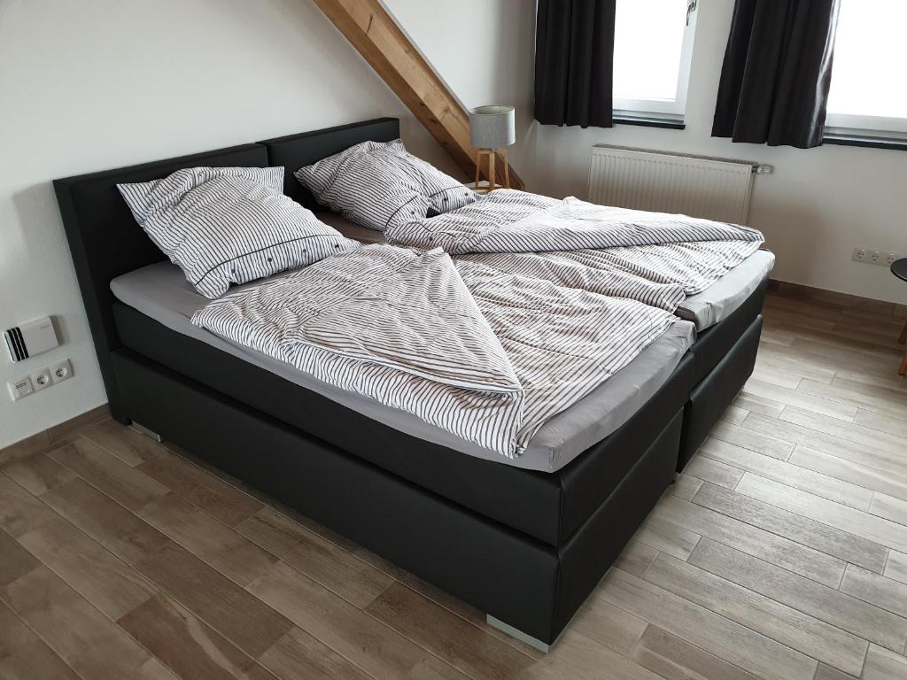 a bed with a black frame and pillows on it at Beim Hooch "Drien" in Brücktal