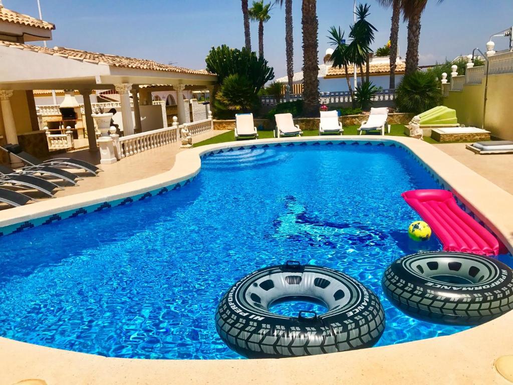 ein Schwimmbad mit zwei Reifen im Wasser in der Unterkunft Villas Yanina Luxe Gran Alacant in Puerto Marino