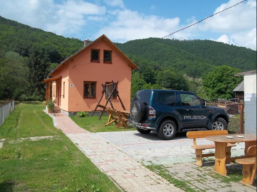 um camião azul estacionado em frente a uma casa em Szikla Vendégház em Istenmezeje