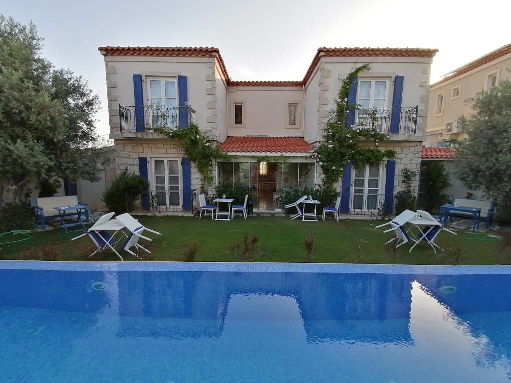 a villa with a swimming pool in front of a house at AlaNarin Konak in Alacati