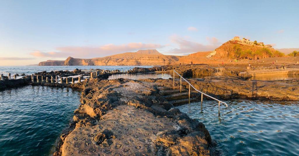 a group of rocks in the water near the ocean at Occidental Roca Negra - Adults Only in Agaete