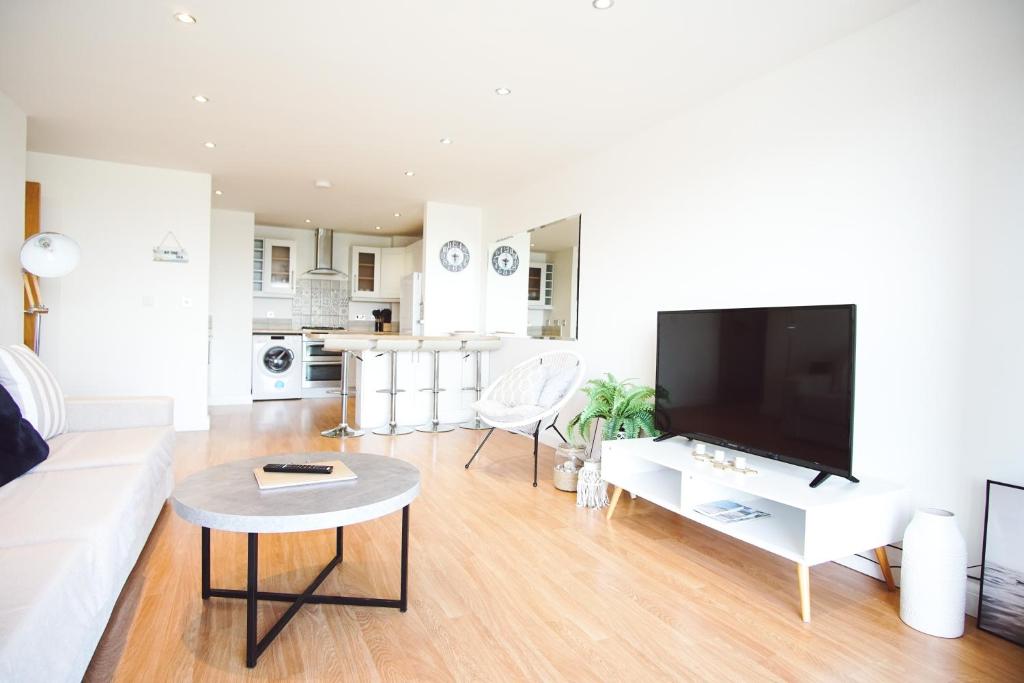 Μια τηλεόραση ή/και κέντρο ψυχαγωγίας στο Stunning Two Bed Sea View Apartment with Pool & Gym