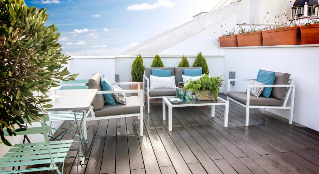 un patio con sillas y mesas en un balcón en Letmalaga Premium Malagueta, en Málaga