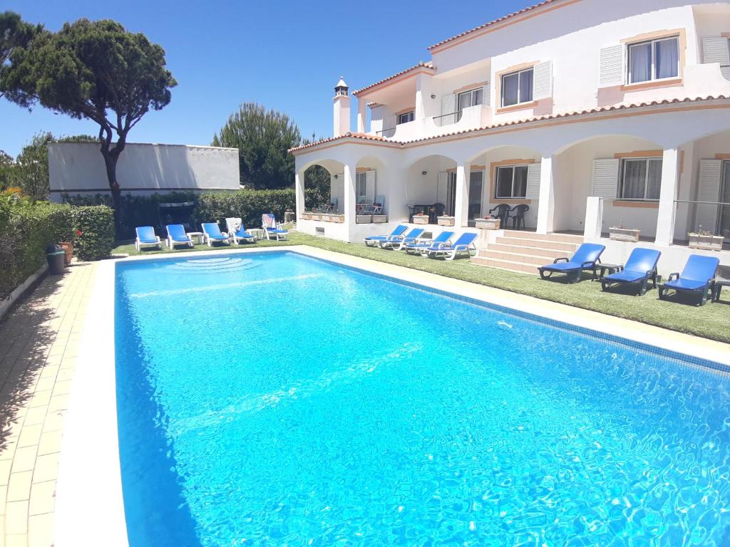a swimming pool in front of a house at Casa Sol da Falesia in Albufeira