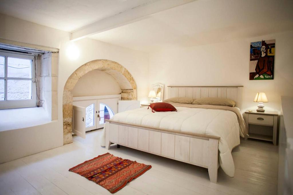 Un pat sau paturi într-o cameră la Charming House Ortigia