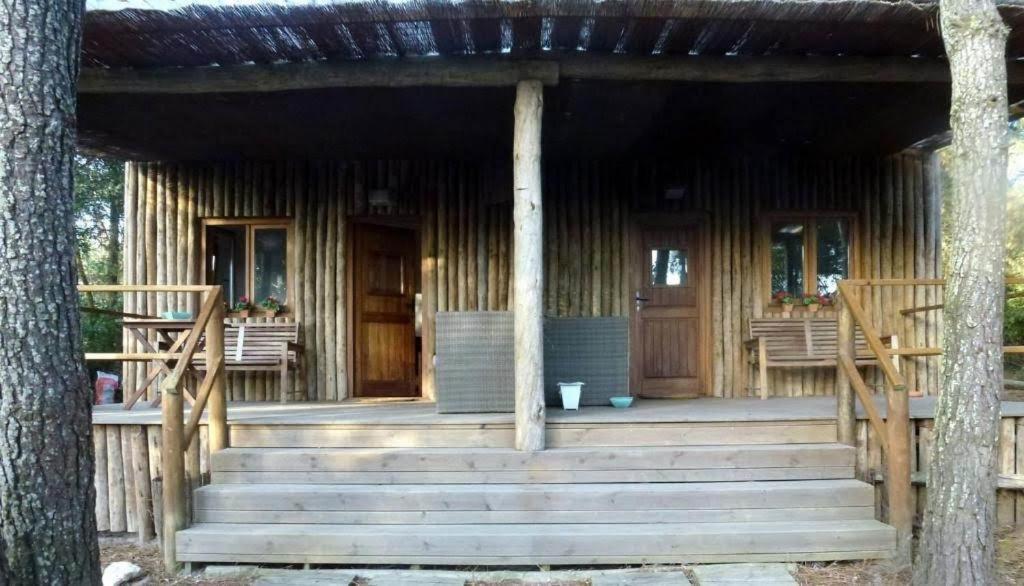 a log cabin with stairs leading to a porch at Bungalow Beach in Brejao