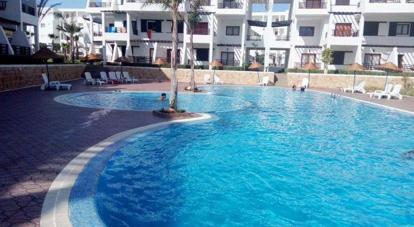 a large swimming pool in front of a building at Résidence Tamuda Golf à Cabo Negro in Cabo Negro