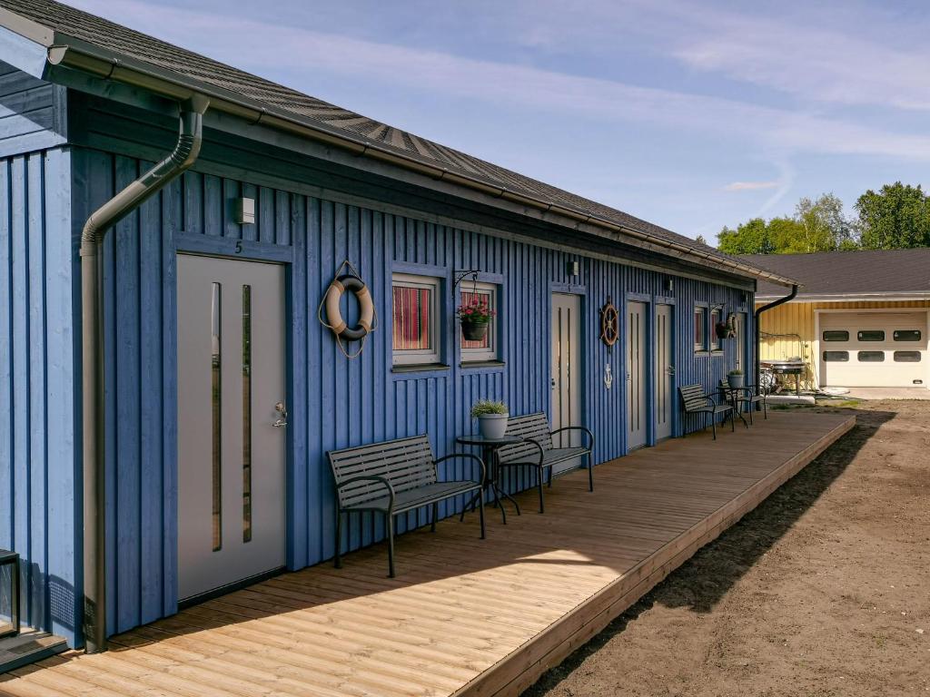 un bâtiment bleu avec des tables et des chaises sur une terrasse dans l'établissement Kihnu Külalistemaja, à Lemsi