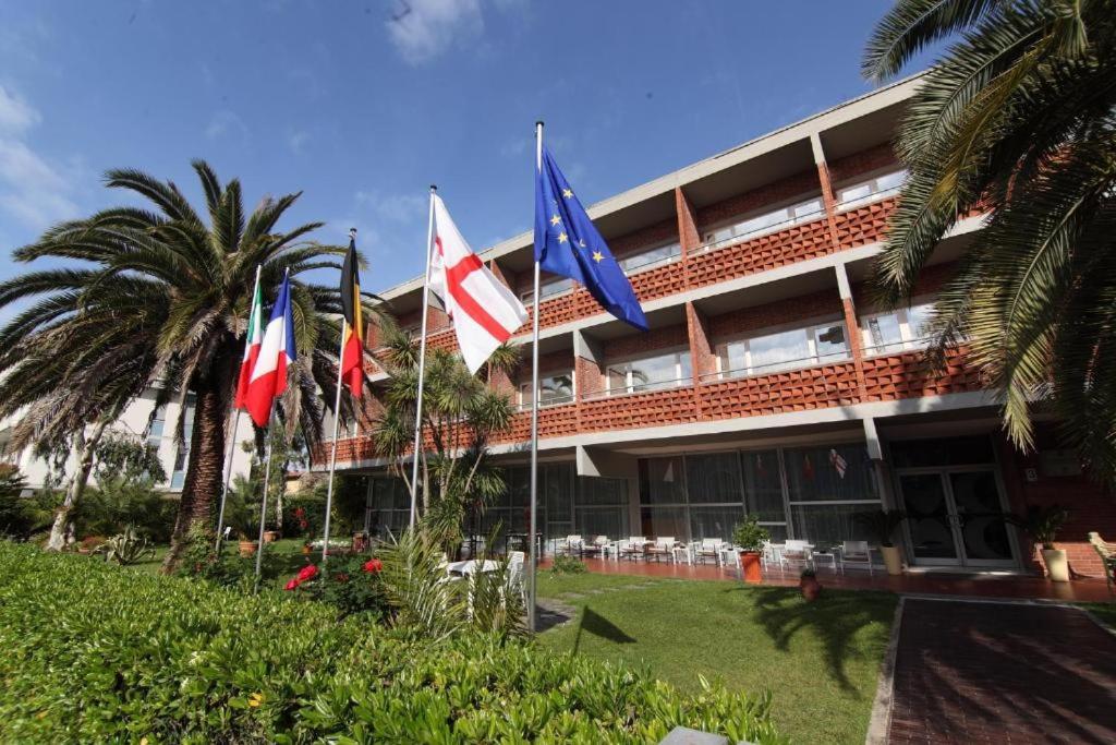 un hotel con banderas frente a un edificio en Hotel Marina en Marina di Massa
