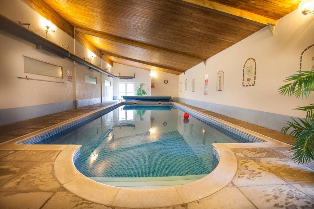 ein Schwimmbad in einem Gebäude mit Pool in der Unterkunft Swift Cottage in Broadhempston