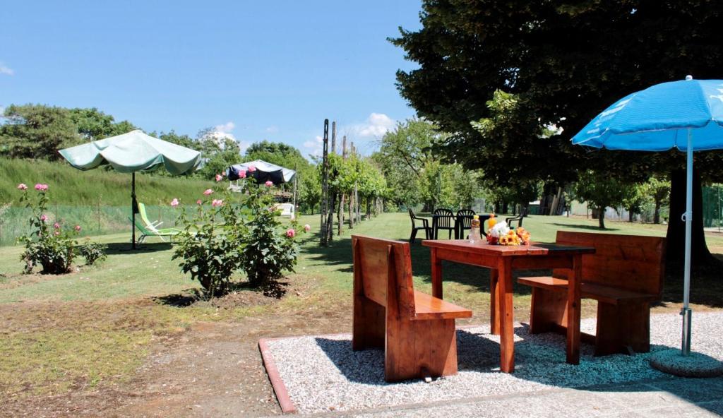 una mesa y un banco con una sombrilla azul en VILLA LILLI en Ferrara