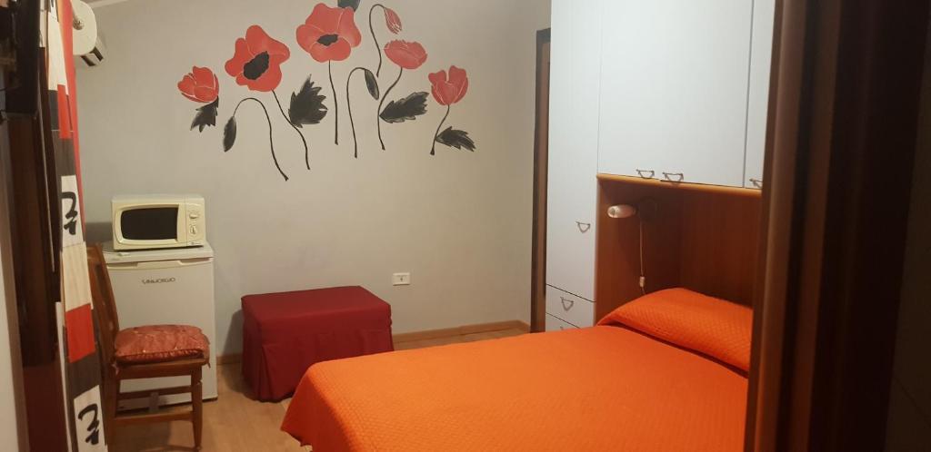 Dormitorio pequeño con cama y microondas en B&B Girasole, en Colleferro