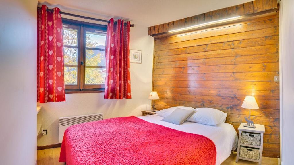 a bedroom with a large bed with a wooden wall at Tovassiere - Apt B115 - BO Immobilier in Châtel