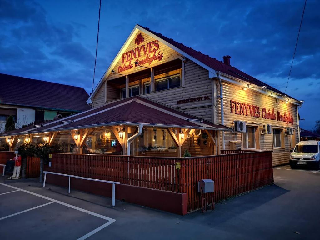 a restaurant with a sign on the side of a building at Fenyves Csárda Vendégház in Nyíradony