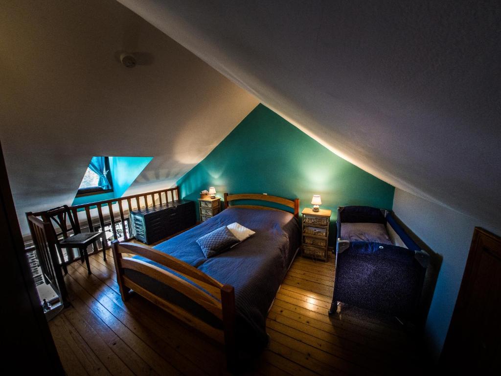 1 dormitorio en el ático con 1 cama y 1 silla en B&B La Grange en Durbuy