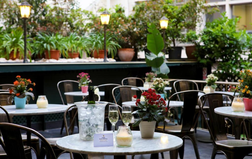 eine Gruppe von Tischen und Stühlen mit Blumen darauf in der Unterkunft Hotel Continental Barcelona in Barcelona