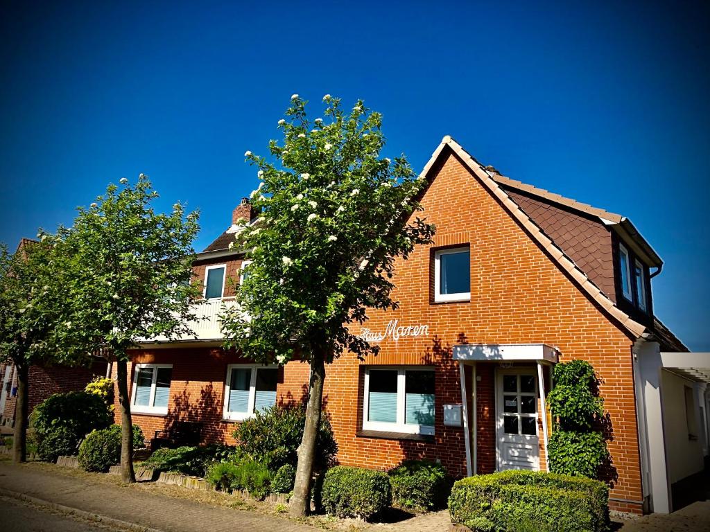 a brick house with a tree in front of it at Pension Maren in Büsum