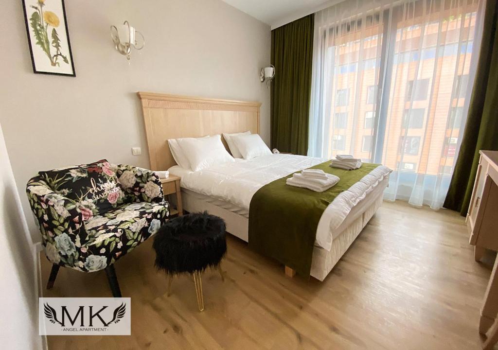 a bedroom with a bed and a chair at MK Angel Apartment in Krakow