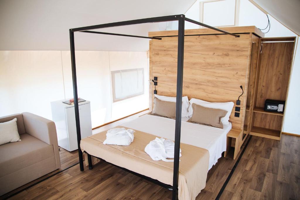 a bedroom with a canopy bed and a couch at Nabi Resort Glamping & SPA in Castel Volturno