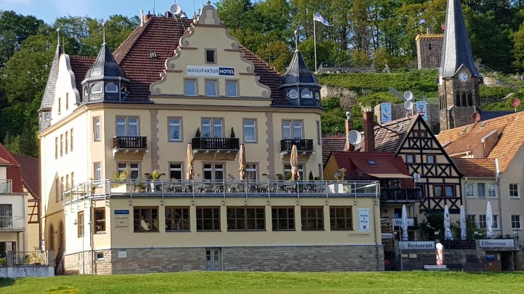 ein großes Gebäude mit Balkon darüber in der Unterkunft Manufaktur Boutique Hotel in Stadt Wehlen