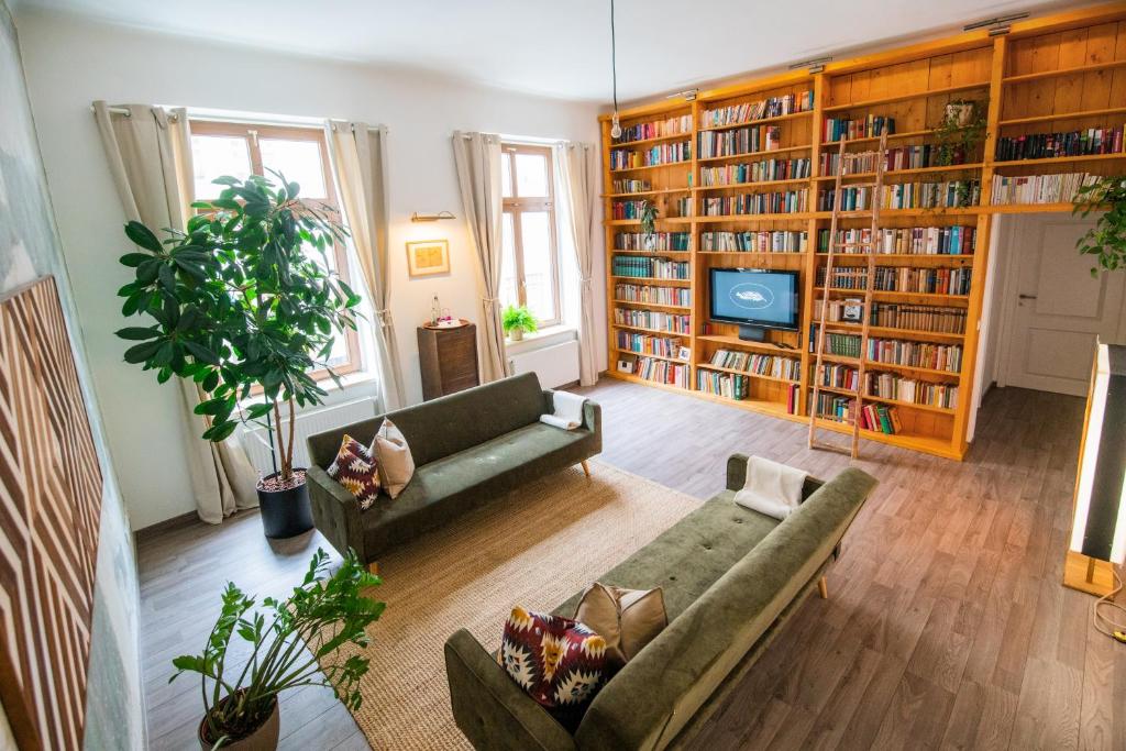 a living room with two couches and a tv at theleaf - design apartment & café in Leipzig