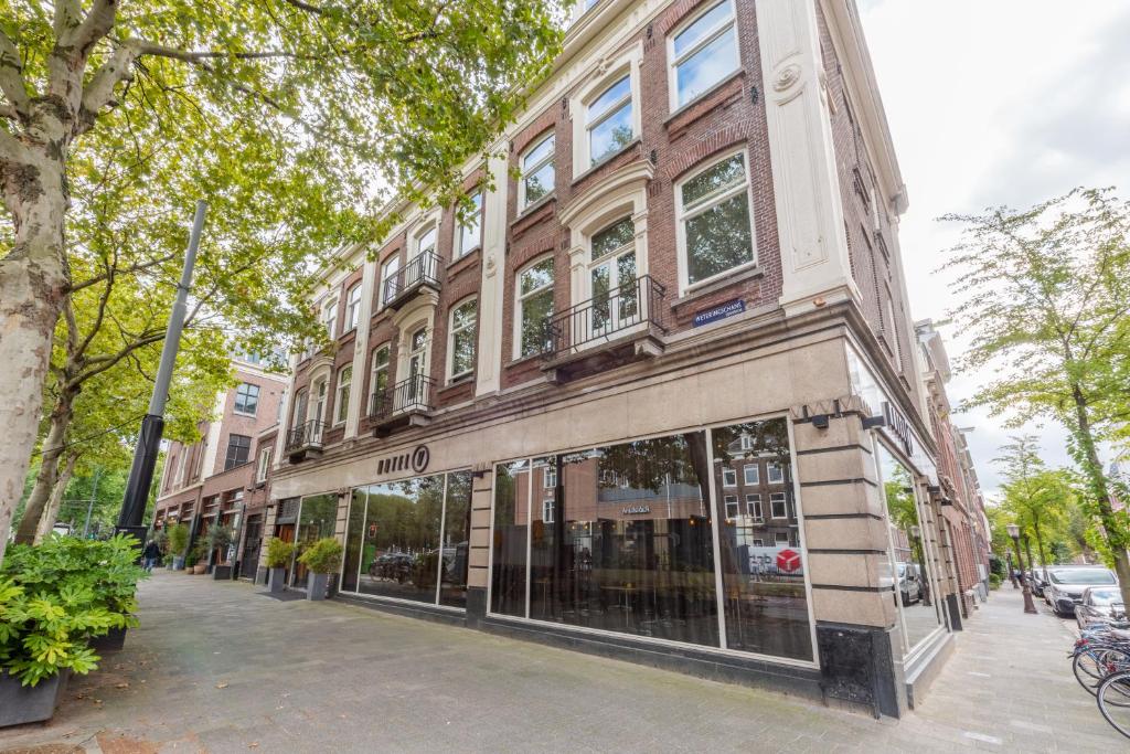 un bâtiment dans une rue de la ville avec un magasin dans l'établissement Hotel V Frederiksplein, à Amsterdam