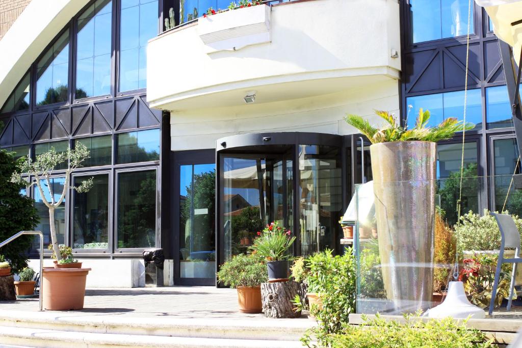 un bâtiment avec des plantes devant lui dans l'établissement Hotel Ombra, à Riccione