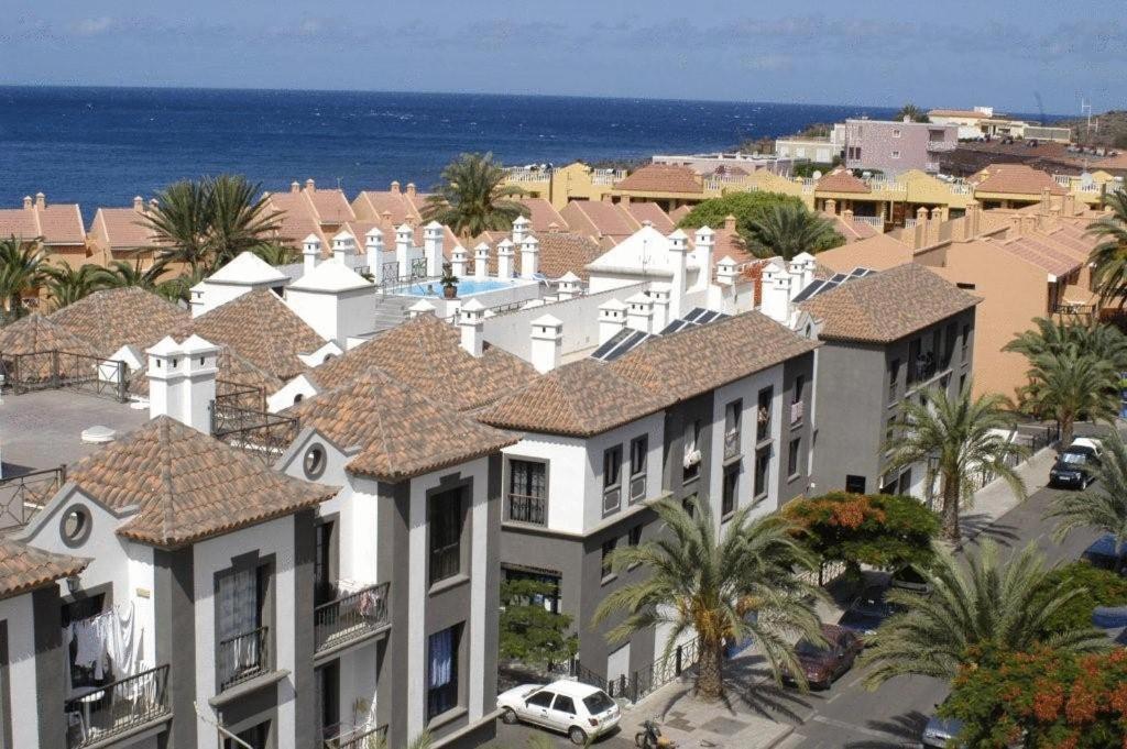 - une vue aride sur un bâtiment avec des palmiers et l'océan dans l'établissement Apartamentos Las Mozas, à Valle Gran Rey