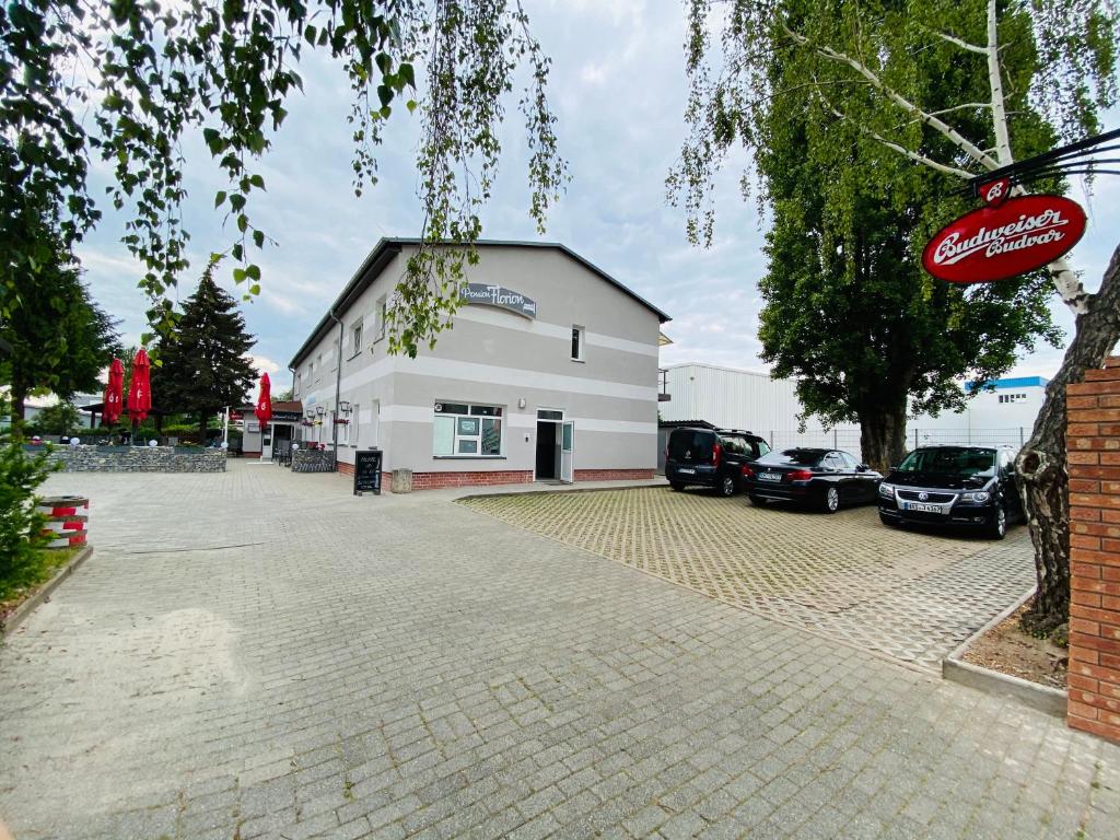 a building with cars parked in a parking lot at Pension Florion in Bernburg