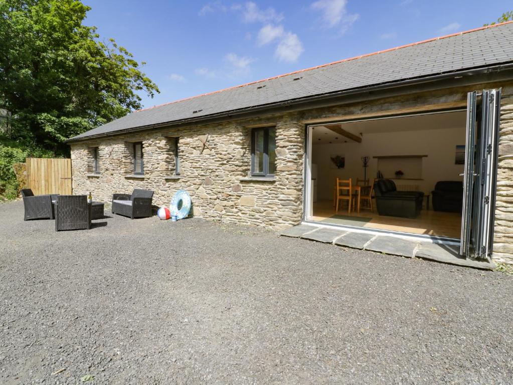 a stone house with a large sliding glass door at The Cart House in St Austell