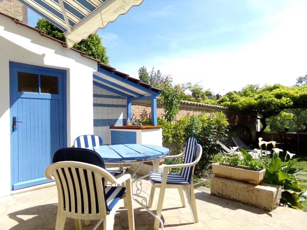 eine Terrasse mit einem Tisch, Stühlen und einem Grill in der Unterkunft Doubs Séjour - Maison de vacances in Verdun-sur-le-Doubs